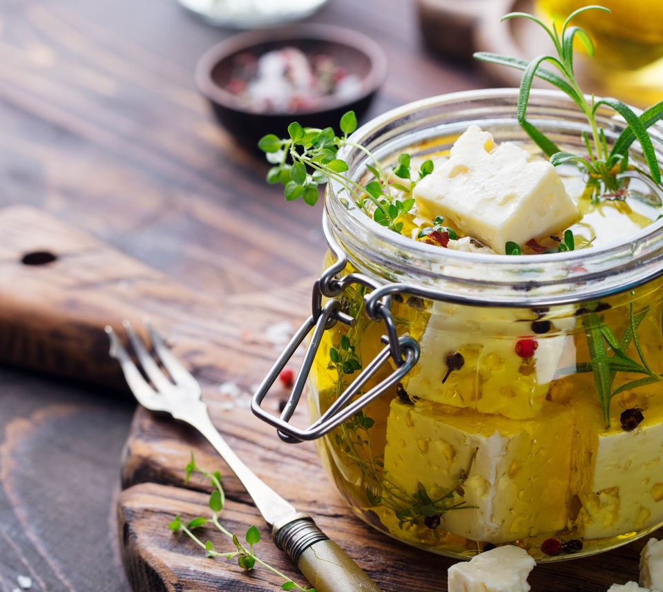 Feta mit Kräutern und Olivenöl im Glas
